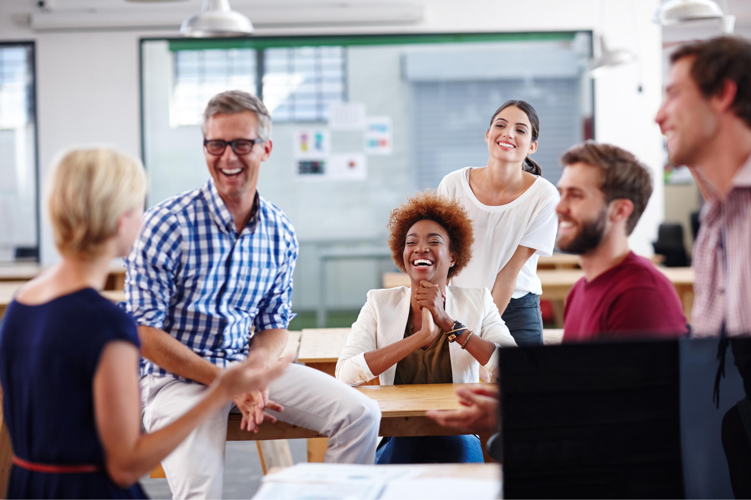 Team laughing and collaborating in an office workplace
